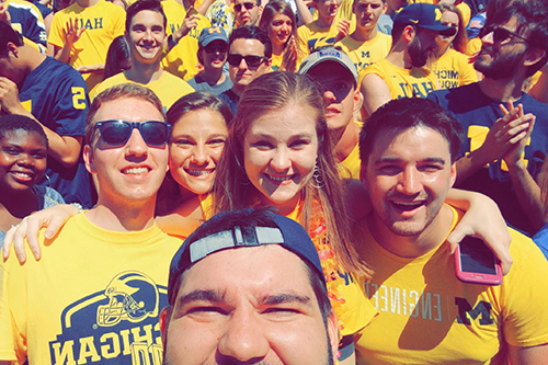 group of students in Michigan gear at the Big House during gameday